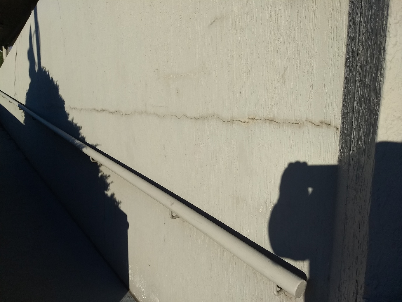 Cracks, staining and surface build-up on an exterior wall